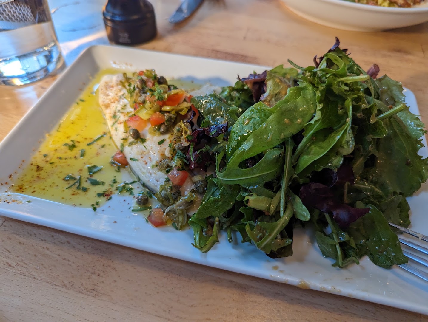 Un filet de poisson et une grande salade aux herbes