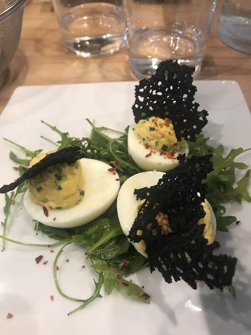 Un œuf garni avec des feuilles vertes et une tuile noire